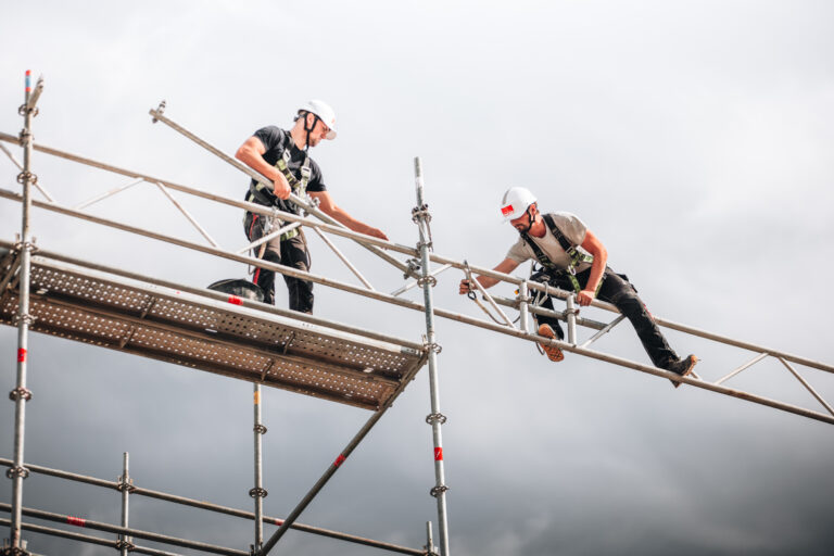 Deux ouvriers montent un échafaudage, sécurité visible