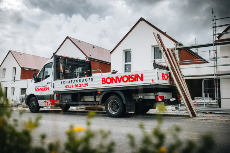 Camion d&#039;échafaudages Bonvoisin devant bâtiment en construction