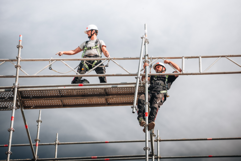 Ouvriers équipés sécurisent une échafaudage métallique